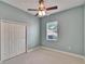 This bedroom has light-colored walls, carpet, a window for natural light, and a ceiling fan at 1742 Oakwood Estates Dr, Plant City, FL 33563