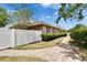 Brick paver walkway leading to a well-maintained home with a white picket fence at 1742 Oakwood Estates Dr, Plant City, FL 33563