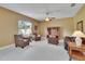 Living room featuring neutral carpet, a ceiling fan, a window, and access to more living space at 1742 Oakwood Estates Dr, Plant City, FL 33563