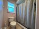 Standard bathroom featuring a toilet next to the window and shower with gray curtain at 206 Soldier Ct, Seffner, FL 33584