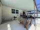 Covered patio with rustic wooden picnic table and adjacent elevated deck and stairs at 206 Soldier Ct, Seffner, FL 33584
