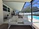 Screened patio with bench seating overlooking swimming pool and fenced backyard at 206 Soldier Ct, Seffner, FL 33584