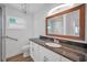 Bathroom with granite countertops, white cabinets, a large framed mirror, and chrome hardware at 2200 Horan S Way, Gulfport, FL 33707