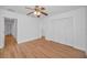 Spacious bedroom with wood-look floors, ceiling fan, and a large closet with white sliding doors at 2200 Horan S Way, Gulfport, FL 33707