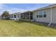 Serene backyard showcasing green lawn, a screened-in porch, and manicured landscaping around the property at 2419 Richmond Greens Ct, Sun City Center, FL 33573