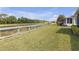 Picturesque backyard featuring lush grass, a wooden fence, and tranquil views of a pond or lake at 2419 Richmond Greens Ct, Sun City Center, FL 33573