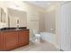 Well-lit bathroom with a dark vanity, ample storage and a shower-tub combination at 2419 Richmond Greens Ct, Sun City Center, FL 33573