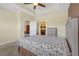 Bedroom with tan walls, neutral carpet, an entrance to the bathroom, and a ceiling fan at 2419 Richmond Greens Ct, Sun City Center, FL 33573