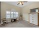 Bright bedroom features shuttered window, neutral carpet, rocking chair and ample storage at 2419 Richmond Greens Ct, Sun City Center, FL 33573