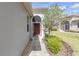 Inviting front entrance features an arched doorway, garden bed and well-manicured lawn at 2419 Richmond Greens Ct, Sun City Center, FL 33573