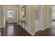 Inviting hallway with hardwood floors, archway, a console table, and a view of a bathroom at 2419 Richmond Greens Ct, Sun City Center, FL 33573