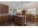 Open concept kitchen with island seating, granite counters, and hardwood floors at 2419 Richmond Greens Ct, Sun City Center, FL 33573
