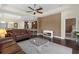 Cozy living room featuring a brown accent wall, hardwood floors, and an open flow to the kitchen at 2419 Richmond Greens Ct, Sun City Center, FL 33573