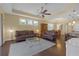 Open-concept living room with brown leather sofas, hardwood floors, and adjacent dining area at 2419 Richmond Greens Ct, Sun City Center, FL 33573