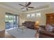 Bright living room with hardwood floors, leather furniture, and access to the outdoor patio at 2419 Richmond Greens Ct, Sun City Center, FL 33573