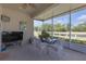 Screened patio with white furniture, a table with plants, and a TV overlooking a canal at 2419 Richmond Greens Ct, Sun City Center, FL 33573