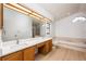 Bright bathroom with a double sink vanity, a soaking tub, and a glass-enclosed shower at 2925 Starmount Dr, Valrico, FL 33596