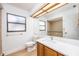 Bright bathroom featuring a single sink vanity, large mirror, and accessible shower with handrails and tiled walls at 2925 Starmount Dr, Valrico, FL 33596
