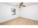 A bright bedroom with hardwood floors, a ceiling fan, white walls, and a window that provides natural light at 2925 Starmount Dr, Valrico, FL 33596