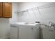 Bright laundry room with washer, dryer, utility sink, and storage shelves at 2925 Starmount Dr, Valrico, FL 33596
