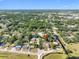 Aerial view of the property and surrounding neighborhood with mature trees at 303 National Orange Ave, Oldsmar, FL 34677