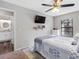 Bedroom featuring a ceiling fan, window, television and ensuite bathroom at 303 National Orange Ave, Oldsmar, FL 34677