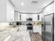 Modern kitchen with stainless steel appliances, white cabinets, and granite countertops at 303 National Orange Ave, Oldsmar, FL 34677