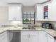 Well-lit kitchen featuring granite countertops, stainless steel sink and appliances, and white cabinetry at 303 National Orange Ave, Oldsmar, FL 34677