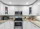 Efficient kitchen features stainless steel appliances, granite counters, and stylish white cabinetry at 303 National Orange Ave, Oldsmar, FL 34677