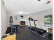 Workout room featuring exercise equipment and a cozy fireplace, perfect for maintaining an active lifestyle at home at 303 National Orange Ave, Oldsmar, FL 34677