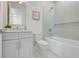 Bright bathroom with a tub and shower combo, modern vanity, and white tiling at 3496 Amberjack Dr, Hernando Beach, FL 34607
