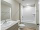 Clean bathroom with a single vanity, toilet, and a shower-tub combo with tiled walls at 37214 Sagemoor Dr, Zephyrhills, FL 33541
