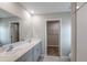 Well-lit bathroom featuring a double sink vanity, large mirror, and tiled shower at 37214 Sagemoor Dr, Zephyrhills, FL 33541