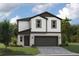 Two-story home with white siding, a two-car garage, and a well-manicured lawn at 37214 Sagemoor Dr, Zephyrhills, FL 33541