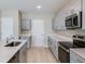 Modern kitchen featuring gray cabinetry, quartz countertops, and stainless steel appliances at 37214 Sagemoor Dr, Zephyrhills, FL 33541