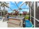 Enclosed back porch featuring a hot tub, grill, and covered seating under a screen enclosure at 424 Island Cay Way, Apollo Beach, FL 33572