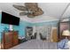 Bedroom view showcasing a work space, wall-mounted TV, and a large ceiling fan at 424 Island Cay Way, Apollo Beach, FL 33572