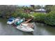 Aerial view of a private dock with three boats and waterfront property among tropical foliage at 424 Island Cay Way, Apollo Beach, FL 33572