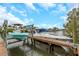 Waterfront property featuring a private dock with boat lifts under a cloudy sky at 424 Island Cay Way, Apollo Beach, FL 33572
