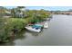 Waterfront property featuring a private dock with three boats nestled along a serene canal at 424 Island Cay Way, Apollo Beach, FL 33572