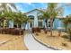 Lovely one-story home with a light-blue facade, arched entryway, and tropical landscaping at 424 Island Cay Way, Apollo Beach, FL 33572