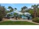 Beautiful light-blue single-Gathering home with a metal roof, palm trees, and a well-manicured lawn at 424 Island Cay Way, Apollo Beach, FL 33572