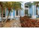 Home exterior featuring a glass front door with tropical landscaping, bushes, and a seating area at 424 Island Cay Way, Apollo Beach, FL 33572