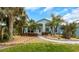 Charming one-story home with a light-blue facade, arched entryway, palm trees, and manicured front yard at 424 Island Cay Way, Apollo Beach, FL 33572