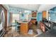 Bright kitchen with an island cooktop, wood cabinets, and stone floors at 424 Island Cay Way, Apollo Beach, FL 33572