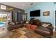 Comfortable living room featuring a leather sofa, stone floors, and sliding glass doors to the pool at 424 Island Cay Way, Apollo Beach, FL 33572