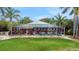 Screened-in pool area surrounded by landscaped greenery, palm trees, and blue skies at 424 Island Cay Way, Apollo Beach, FL 33572