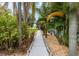 Paver walkway leading up to the blue house through well-kept landscaping and tropical foliage at 424 Island Cay Way, Apollo Beach, FL 33572