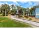 Exterior of home surrounded by green lawn, walkways, and various palm trees, bushes, and plants at 424 Island Cay Way, Apollo Beach, FL 33572