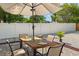 Outdoor patio with dining table, chairs, umbrella, white vinyl fence, pea gravel, and brick border at 439 E Boyer St, Tarpon Springs, FL 34689